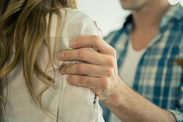 Vergrößerungsansichten für Bild: Nahaufnahme: Das Bild zeigt eine Männerhand, die eine Frau an der Schulter festhält